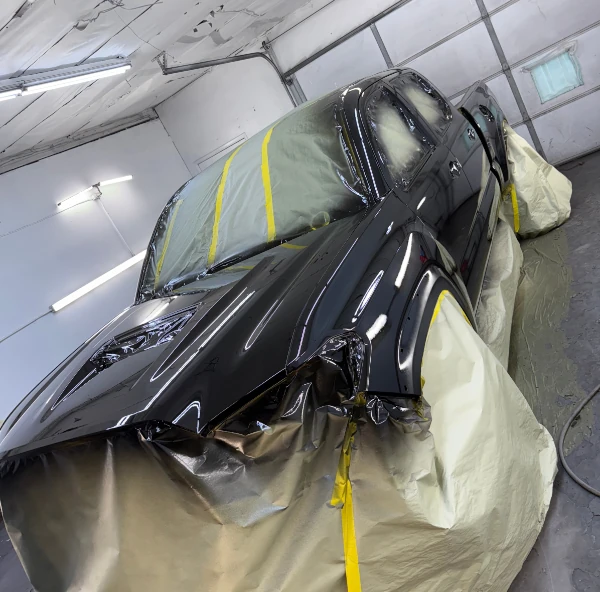 Black pickup truck being painted in the AS Auto Paint Works paint booth